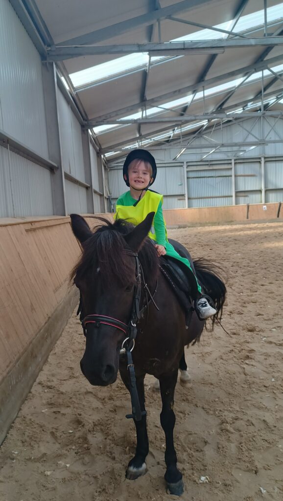 Chłopiec siedzi na koniu 