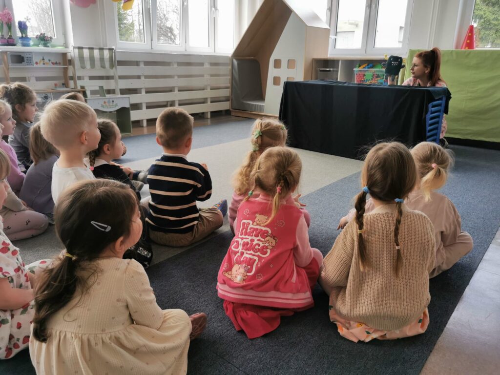 dzieci siedzą na dywanie