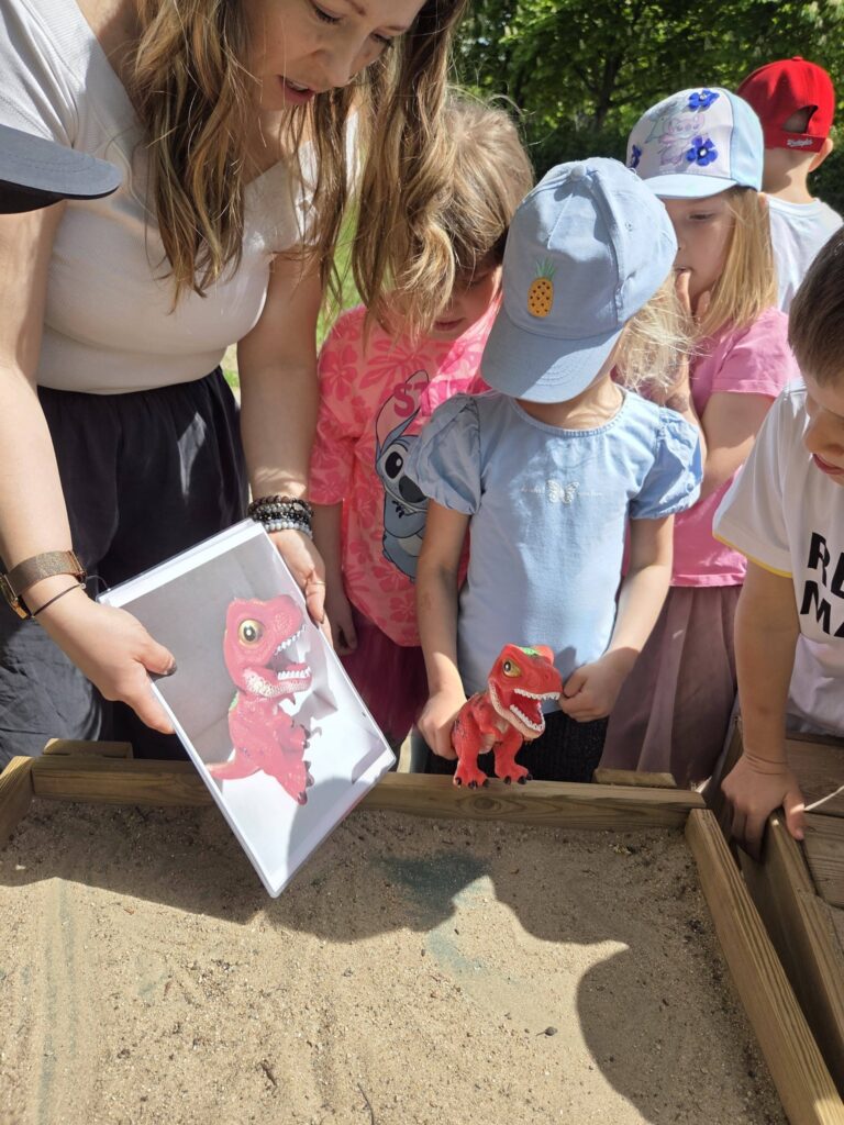 dziewczynki trzymają zabawkowego dinozaura